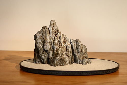 Suiseki on fitted wooden daiza